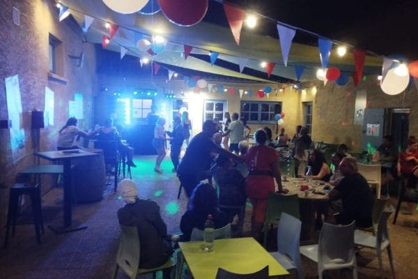 Une soirée dansante sur la terrasse du camping, guirlandes et tables occupées